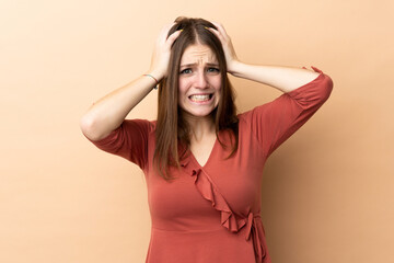 Fototapeta premium Young caucasian woman isolated on beige background doing nervous gesture