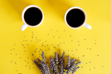 Businessman working morning with cups of hot black coffee and lavender bouquet on yellow background. Top view, copy space, mockup. Flat lay. Spring and modern breakfast food concept.  