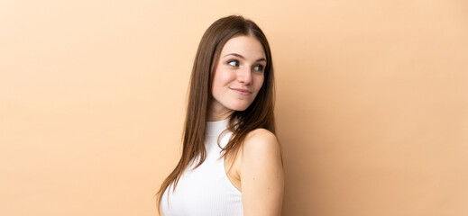 Young caucasian woman isolated on beige background . Portrait