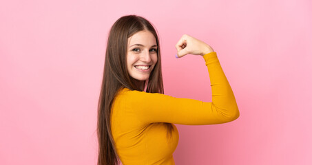 Young caucasian woman isolated on pink background doing strong gesture