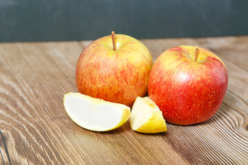 Apples seen from above with two pieces on wooden table