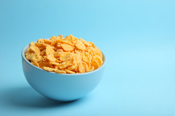 Delicious cornflakes in a plate against colored background. 