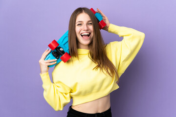 Young caucasian woman isolated on purple background with a skate