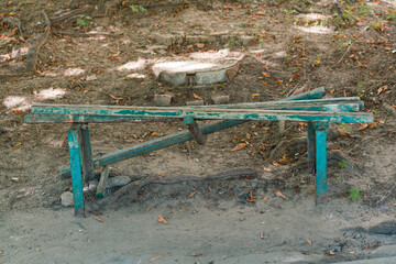 Green broken bench outdoor. Street. Park. Vandals. Wooden. Ground. Damage. Damaged - obrazy, fototapety, plakaty