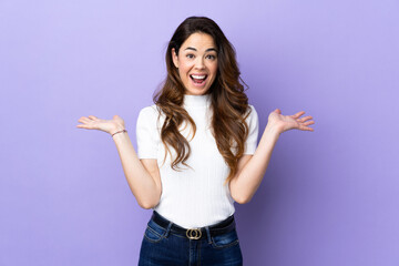 Woman over isolated purple background with shocked facial expression