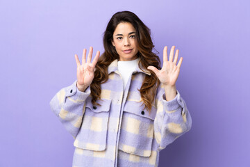 Woman over isolated purple background counting nine with fingers