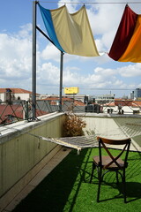 Alter Holzstuhl, Hängematte und grüner Kunstrasen auf der Dachterrasse eines Hotel im Stadtteil...