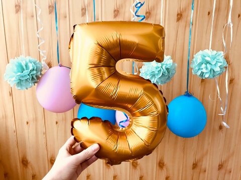 Happy fifth birthday - number five gold balloons, anniversary celebration card with pink and blue decorations