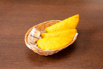 Unvarnished wicker besta with Colombian corn empanadas stuffed with meat stew