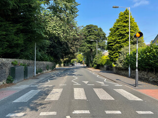 View down, Moorhead Lane, with trees, houses, and a blue sky near, Saltaire, Bradford, UK