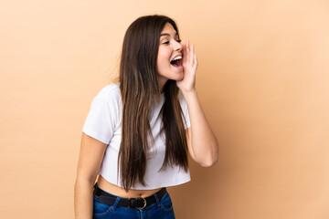 Teenager Brazilian girl over isolated background shouting with mouth wide open to the side