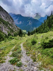 Fototapeta na wymiar Wandern in die Höhen der Alpen in Österreich Richtung Kogelsee. In der Ferne ist Gramais mit seiner Kirche zu erkennen