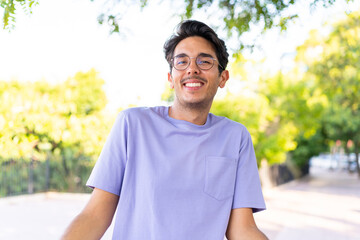 Young caucasian man at outdoors in a park smiling