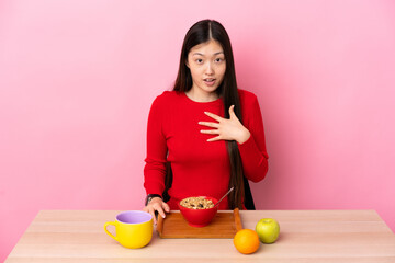 Young Chinese girl  having breakfast in a table pointing to oneself
