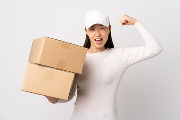 Young delivery Chinese woman over isolated white background celebrating a victory