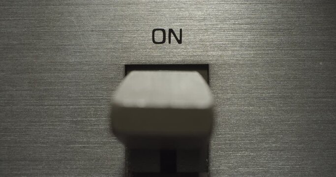 Power Switch "ON". Macro extreme close up on a vintage silver brushed metal stereo system as the power switch flips on and off.