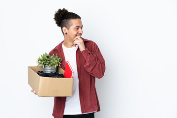 Caucasian man making a move while picking up a box full of things over isolated white background...