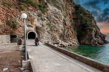 Travelers enter the tunnel on a motorcycle