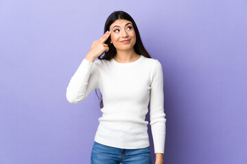 Young brunette woman over isolated purple background with problems making suicide gesture