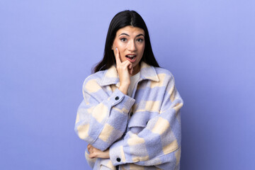 Young brunette woman over isolated purple background surprised and shocked while looking right