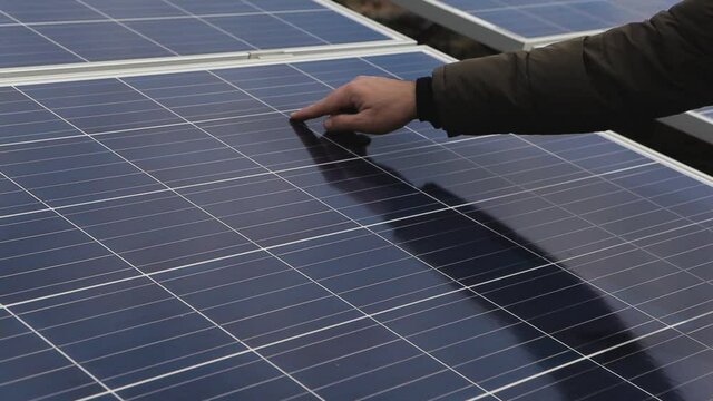 Solar panel engineer control.  Close-up of a young engineer's hand. Checking the cleanliness of solar panels.