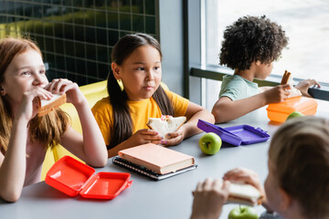 multiethnic children having lunch in school eatery