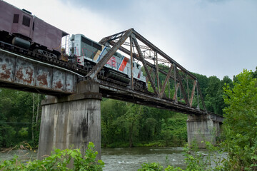 Train crossing Warren through truss bridge over Tuckasegee River on Great Smoky Mountains Railroad, Swain County, North Carolina