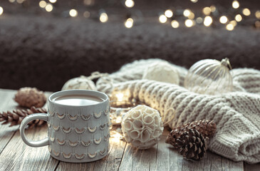 Fototapeta na wymiar Home winter composition with coffee cup and decor details on blurred background.