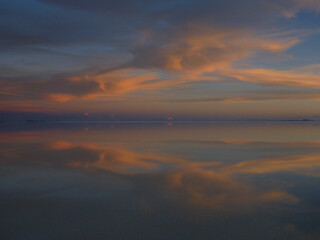 Fototapeta na wymiar ボリビアのウユニ塩湖にて水面に鏡のように反射する夕日