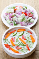 Bowl of delicious and healthy vegan diet food- organic cucumber, carrot, onion, tomato salad with curd, 