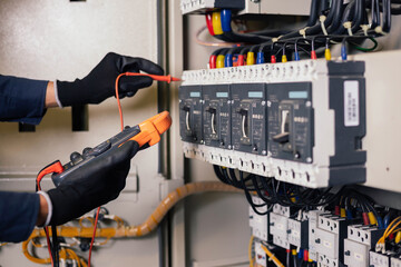 Electrician engineer work tester measuring voltage and current of power electric line in electical...