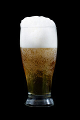 Cold beer with foam in a glass on a black background.