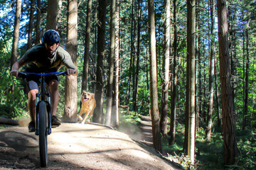 Man Riding his mountain bike with his trail dog.