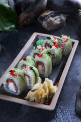 Rolls with salmon and butter cream.Dark background. Vegetarian food.Traditional Japanese dish.Photo on a black background.Vertical photo.Out of focus.