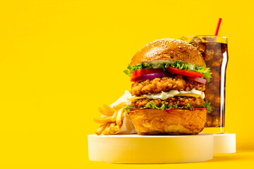 Fresh Big breaded chicken burger with double cutlet, fries and cola on yellow background. Fat unhealthy street food. Copy space - obrazy, fototapety, plakaty