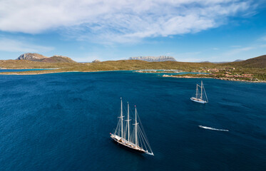 View from above, stunning aerial view of some luxury sailboats sailing on a blue water during a...