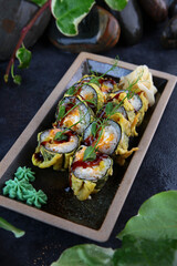 Japanese rolls in batter.Rolls in tempura with salmon and squid. Traditional Japanese cuisine. Vertical photo.Out of focus.Top view.