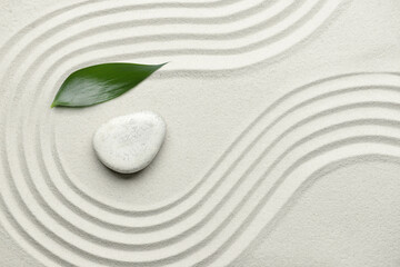 Fototapeta na wymiar Stone and leaf on sand with lines. Zen concept