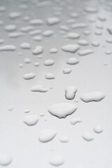 Fototapeta na wymiar Drops of water or rain on a silvery surface.