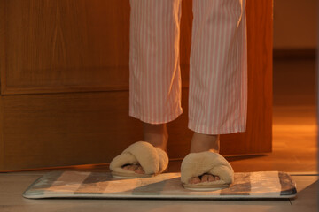 Fototapeta na wymiar Woman wearing soft slippers at home, closeup