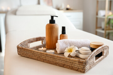 Fototapeta na wymiar Tray with beautiful spa composition on couch in salon