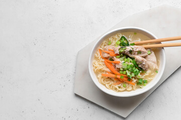 Tasty Chinese soup with chicken in bowl on light background