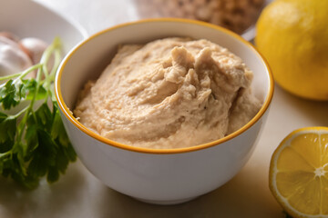 Bowl with tasty hummus on table, closeup