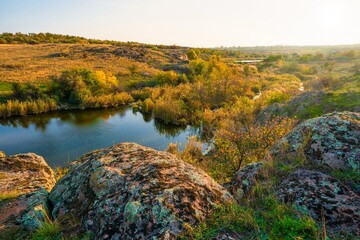 A small pile of stones in a green-yellow field against the background of sky in beautiful Ukraine