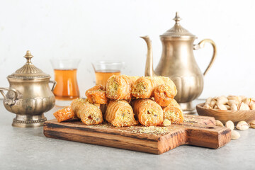Wooden board with delicious baklava on table