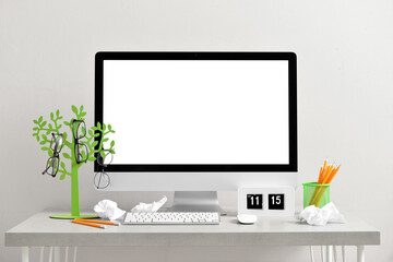 Workspace with modern computer and crumpled paper balls on light background