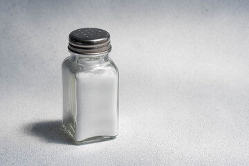 A pile of salt from salt shaker, concept excessive salt intake and white death