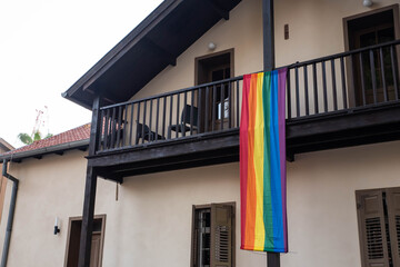 Fototapeta na wymiar House facade windows decorated with the LGBT rainbow flag, gay pride