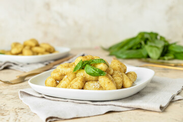 Plate with tasty pesto gnocchi on table
