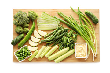 Board with different green vegetables on white background